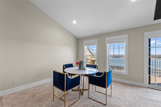 dining room with carpet, lofted ceiling, and baseboards