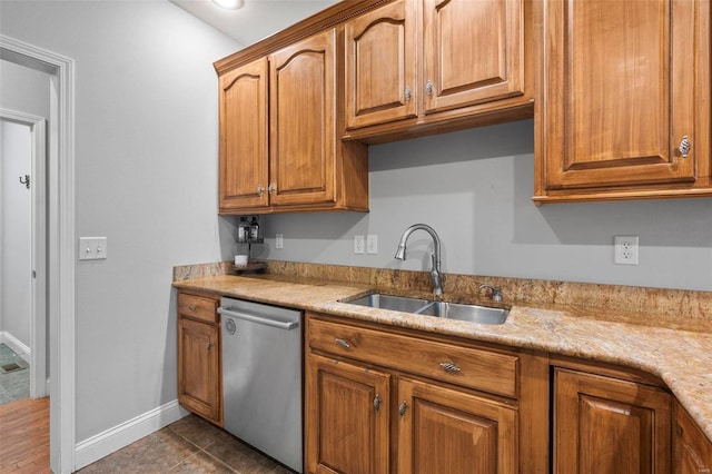 kitchen featuring dark tile patterned floors, dishwasher, and sink