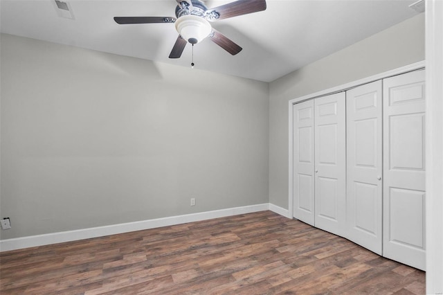 unfurnished bedroom with ceiling fan, wood-type flooring, and a closet