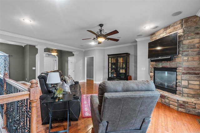 living room with ceiling fan, a fireplace, hardwood / wood-style flooring, and ornamental molding