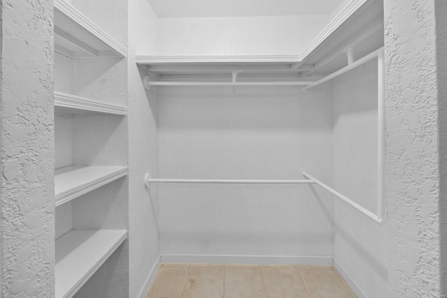 spacious closet with light tile patterned floors