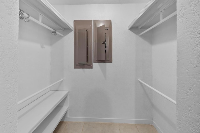 walk in closet with electric panel and light tile patterned floors