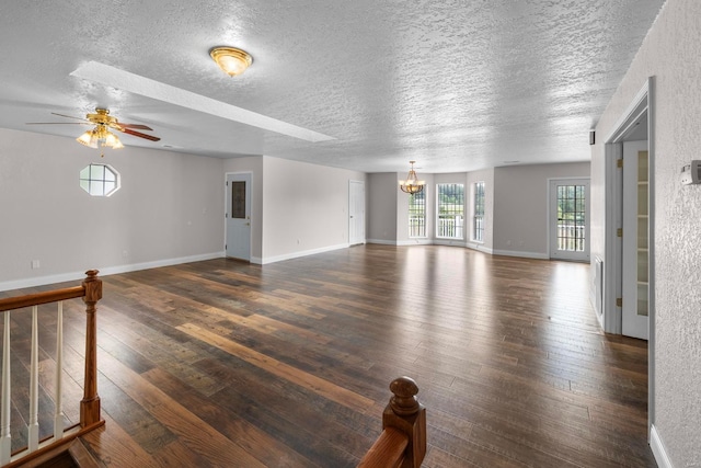 unfurnished living room with ceiling fan with notable chandelier, wood-type flooring, and a textured ceiling