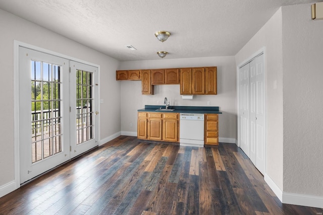 kitchen featuring sink, dishwasher, french doors, dark hardwood / wood-style floors, and a textured ceiling