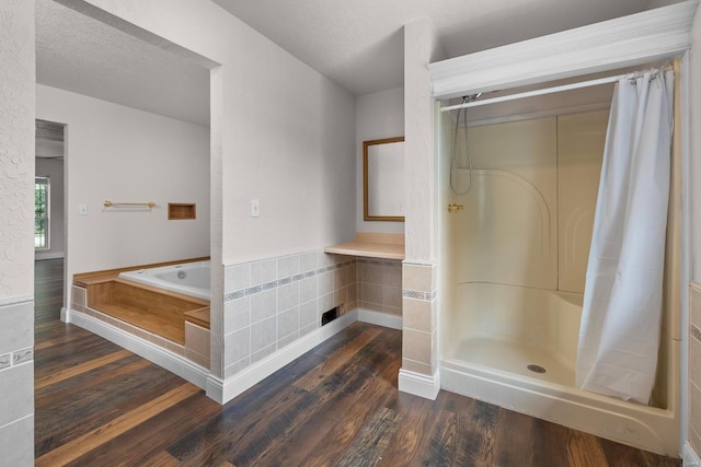 bathroom with separate shower and tub, a textured ceiling, and hardwood / wood-style flooring