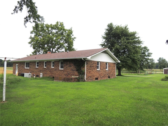 view of home's exterior featuring central AC unit and a yard