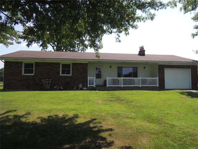 ranch-style house featuring a front yard, covered porch, and a garage