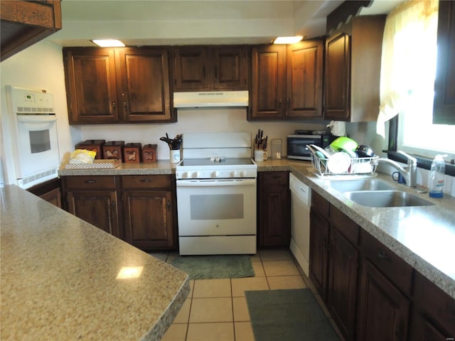 kitchen featuring light tile patterned floors, sink, and white appliances