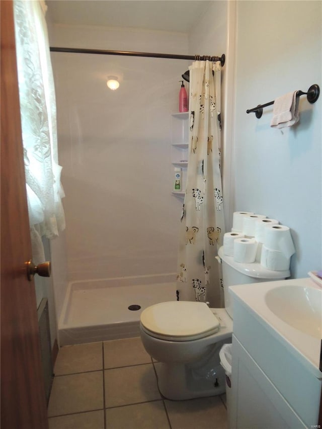 bathroom featuring toilet, a shower with shower curtain, tile patterned floors, and vanity