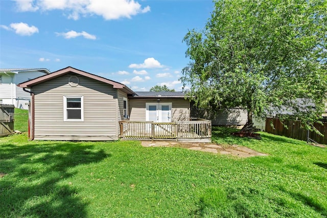 rear view of house featuring a yard and a wooden deck