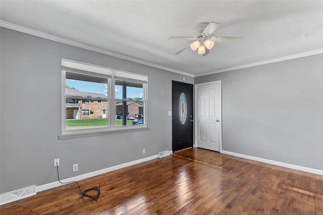 foyer featuring ceiling fan, dark wood-type flooring, a textured ceiling, and ornamental molding