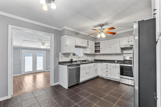 kitchen with french doors, sink, ornamental molding, appliances with stainless steel finishes, and white cabinetry