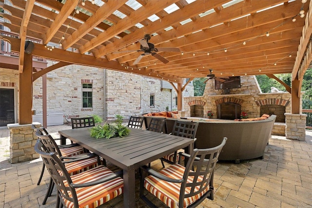 view of patio / terrace featuring ceiling fan, a pergola, and an outdoor stone fireplace