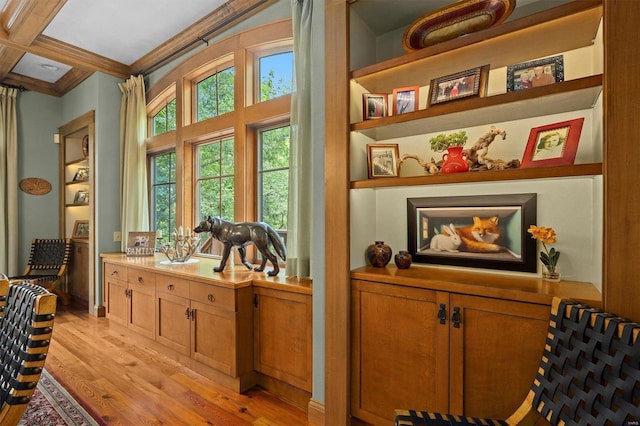 sitting room featuring ornamental molding, light wood-type flooring, beamed ceiling, and coffered ceiling