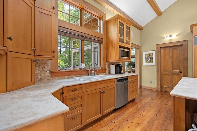 kitchen with light wood-type flooring, sink, a healthy amount of sunlight, and stainless steel dishwasher