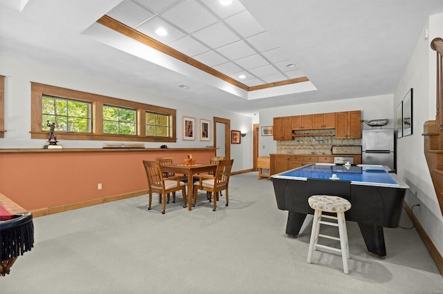 interior space with ornamental molding, a raised ceiling, and sink