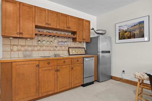 kitchen featuring light carpet, stainless steel appliances, sink, and tasteful backsplash