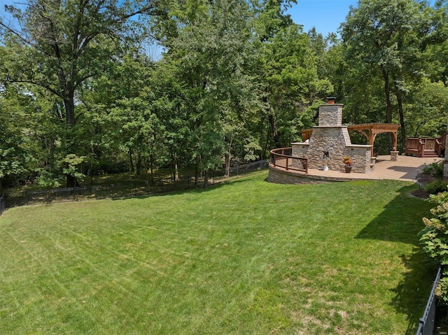 view of yard with an outdoor stone fireplace and a patio area