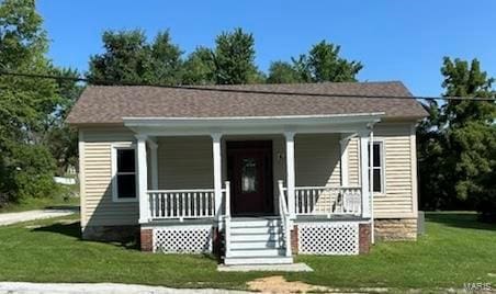 bungalow-style house featuring covered porch and a front lawn