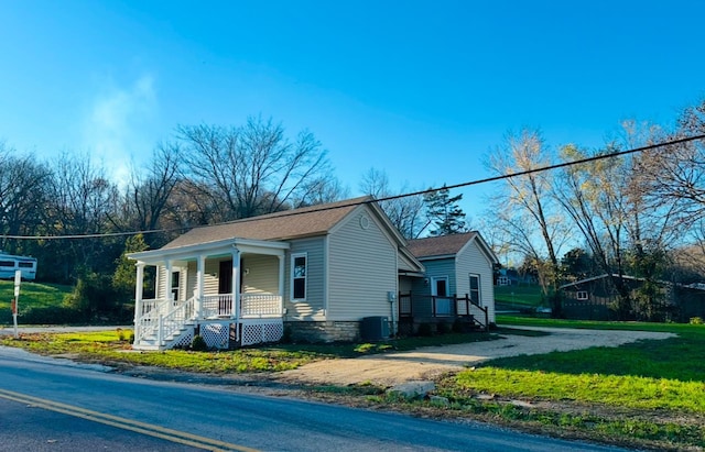 view of front facade featuring a front lawn and cooling unit