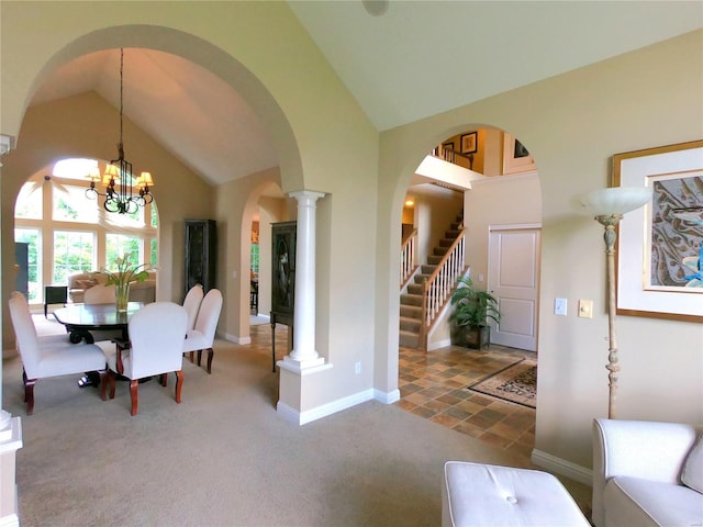 dining space with a notable chandelier, carpet, high vaulted ceiling, and ornate columns