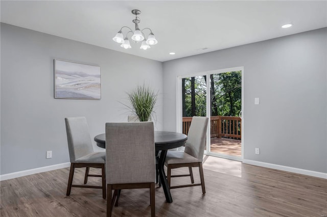 dining space featuring hardwood / wood-style flooring and a notable chandelier