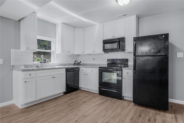 kitchen featuring sink, white cabinets, and black appliances