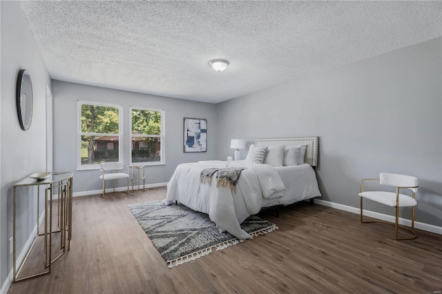 bedroom featuring dark wood-type flooring and a textured ceiling