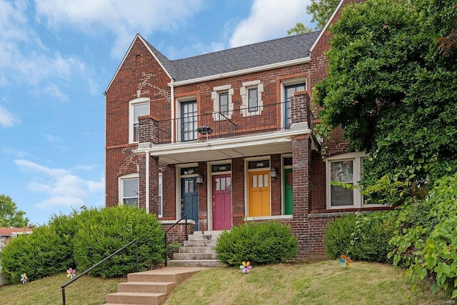 view of front of house featuring a balcony and a front yard