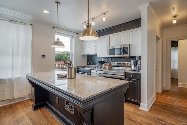 kitchen featuring white cabinets, stainless steel appliances, rail lighting, and light wood-type flooring