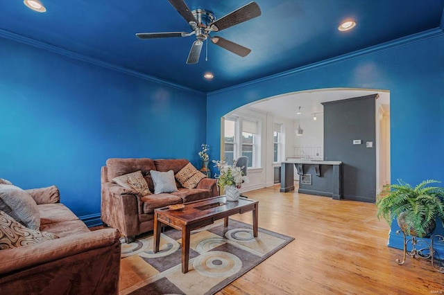 living room featuring ceiling fan, light hardwood / wood-style flooring, and ornamental molding