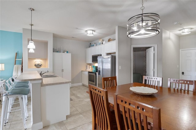 dining room with a notable chandelier, sink, and light tile patterned flooring