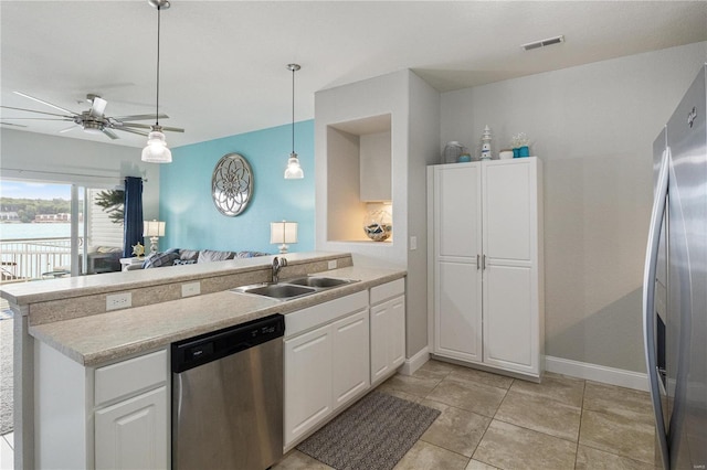 kitchen featuring light tile patterned flooring, ceiling fan, stainless steel appliances, sink, and kitchen peninsula