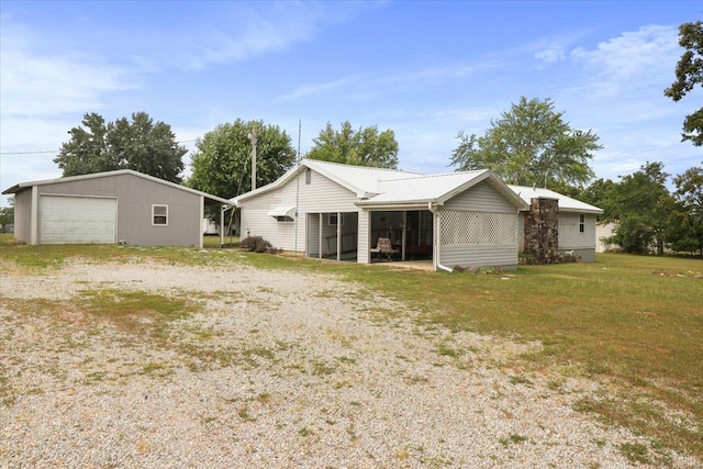 rear view of house featuring a garage and an outdoor structure