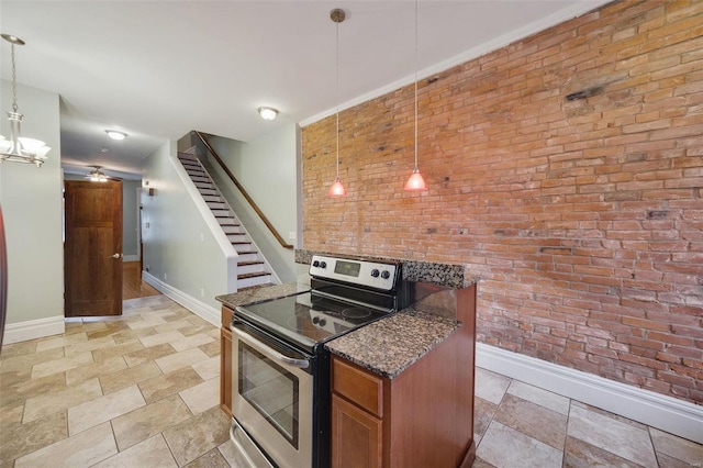 kitchen with brick wall, stainless steel electric range oven, decorative light fixtures, and dark stone countertops