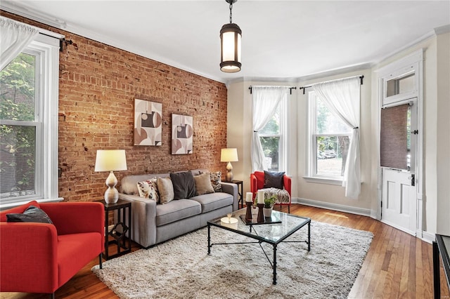 living room with ornamental molding, brick wall, and hardwood / wood-style floors