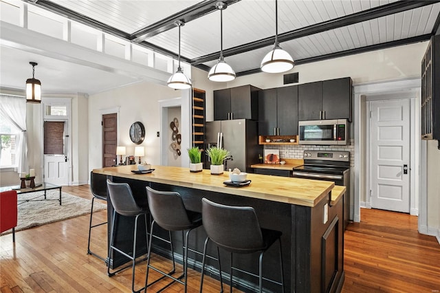 kitchen featuring stainless steel appliances, pendant lighting, and a kitchen breakfast bar