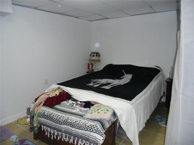 bedroom featuring a drop ceiling and tile patterned floors