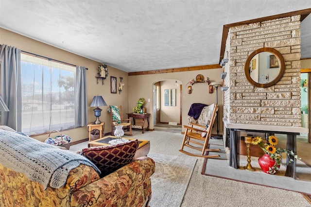 carpeted living room with brick wall, a fireplace, and a textured ceiling