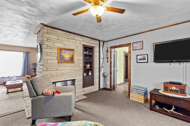 living room featuring carpet floors, a textured ceiling, ceiling fan, and ornamental molding