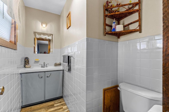 bathroom featuring backsplash, toilet, vanity, tile walls, and wood-type flooring