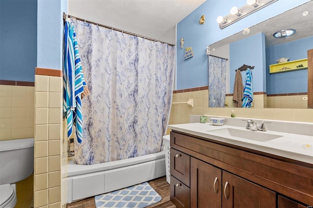 full bathroom featuring shower / bath combination with curtain, toilet, vanity, tile walls, and hardwood / wood-style flooring