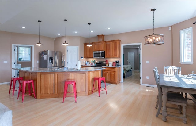 kitchen with pendant lighting, a breakfast bar, a center island, and appliances with stainless steel finishes