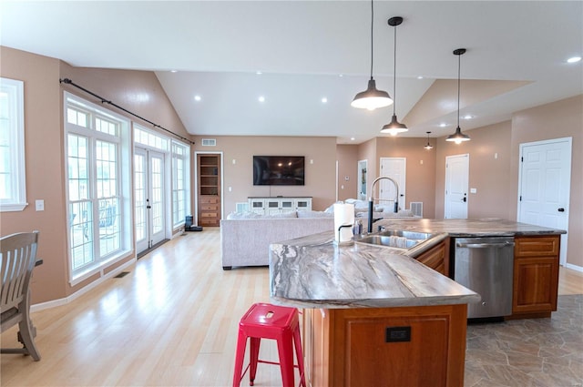 kitchen featuring hanging light fixtures, dishwasher, a kitchen island with sink, and sink