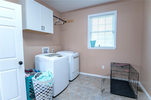 laundry room with washing machine and dryer and cabinets