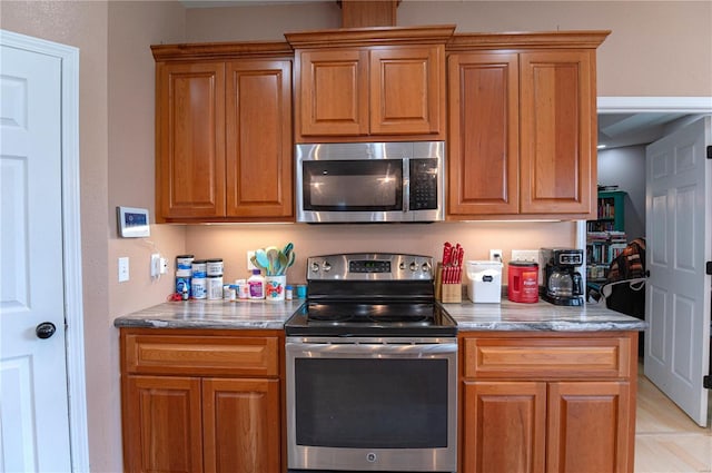 kitchen with stone counters and appliances with stainless steel finishes