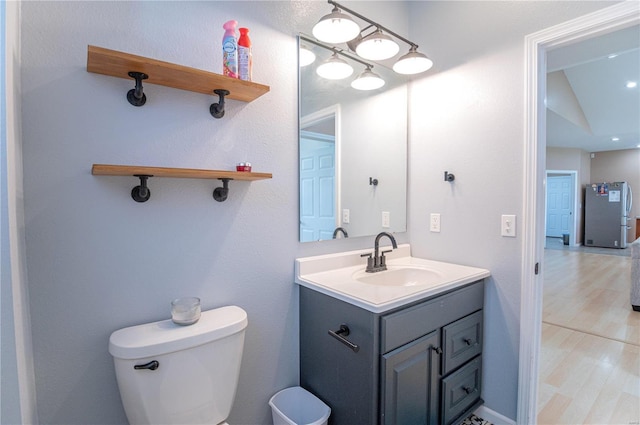 bathroom with vanity, toilet, and wood-type flooring