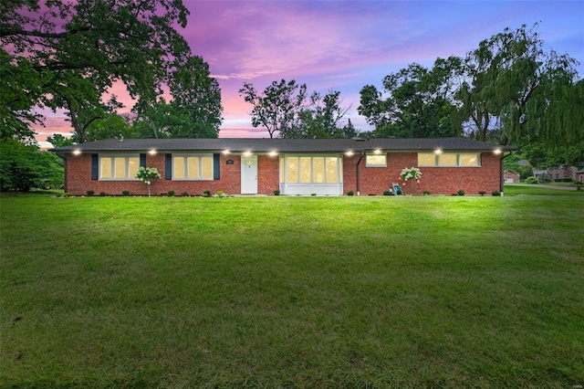 ranch-style home with a lawn