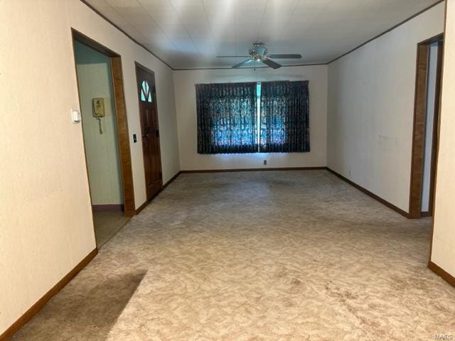 unfurnished room with a ceiling fan, carpet flooring, and baseboards