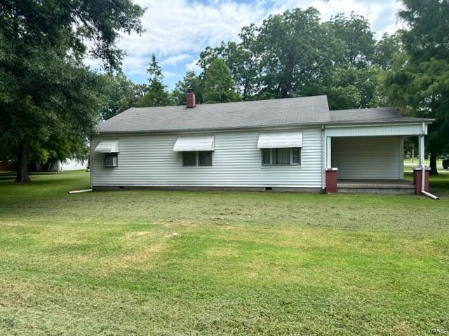 rear view of house featuring a yard